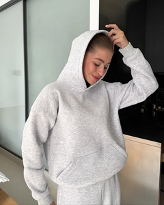 Detailed close-up of grey hooded sweatshirt featuring a ribbed cuff and kangaroo pocket