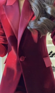 Vue détaillée du blazer en velours rouge avec revers à pointe et bouton unique recouvert