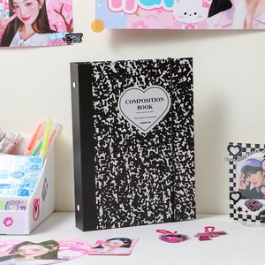 Detail of A5 composition book photocard binder with heart label on desk setup