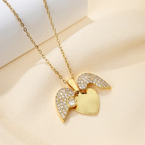 Macro detail of gold-toned heart wing pendant with shimmering micro-pave cubic zirconia