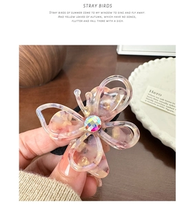 Detail of acetate butterfly hair tie with pink marble texture and a sparkling crystal
