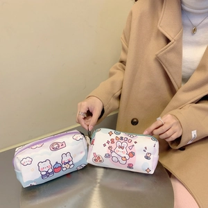 Detail of canvas pouches with cute rabbit and bear prints being held against a coat