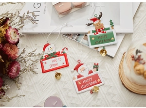Detail of Christmas iron pendants with Santa, snowman and elk designs and golden bells