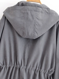 Detail of grey hooded windbreaker featuring adjustable drawstring waist and back stitching