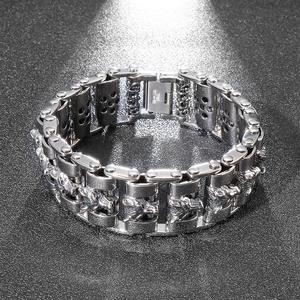 Close-up of industrial silver stainless steel dragon head chain bracelet on black background