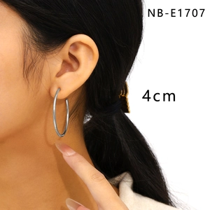 Detail shot of a 4cm silver polished stainless steel hoop earring on a model's ear