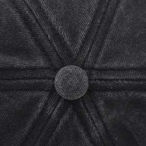 Macro shot of black corduroy baseball cap top showing the fabric button and stitching detail