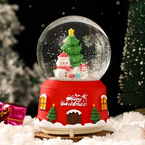 Christmas music box crystal ball with snowman and Christmas tree on a red base