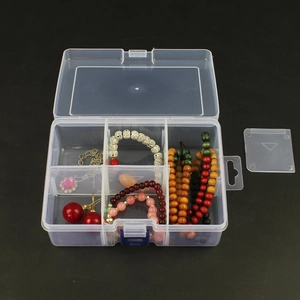 Detailed top view of a transparent multi-grid jewelry box with various accessories
