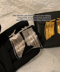 Macro shot of silver tassel drop earrings with delicate vertical metal chain strands