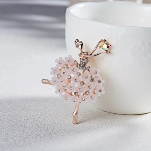 Detail of ballerina brooch with pink flower tutu and crystal accents on white ceramic
