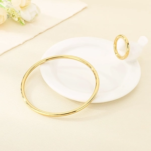 Detail of 18k gold plated 3mm round wire bracelet and ring set on ceramic tray