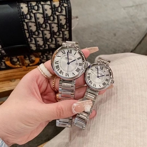 Detail of silver steel couple watches with Roman numerals and date window shown on hand