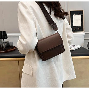 Detailed side view of brown square crossbody bag with adjustable wide shoulder strap