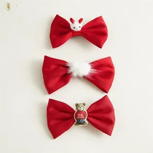 Close-up of red velvet bow hair ties with cute white rabbit and brown bear plush ornaments