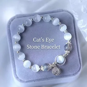 Detail of light blue cat eye bead bracelet with silver hollow charm in a jewelry box