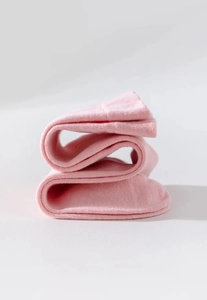 Dettaglio ravvicinato dei calzini in cotone rosa che mostra la trama morbida della maglia