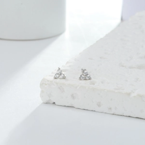 Close-up of minimalist S925 sterling silver triangle stud earrings with sparkling stones