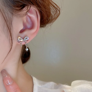 Vue macro d'une boucle d'oreille nœud en argent avec pendentif en zircon sur le modèle