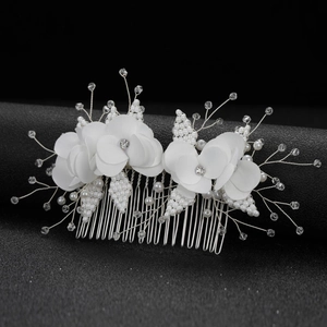 Close-up of bridal flower hair comb with white silk petals, pearls and crystals