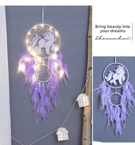 Detail of unicorn dream catcher with purple feathers, pearls and warm LED fairy lights