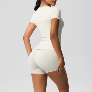 Detail view of cream slim fit short sleeve yoga top and high waist shorts set