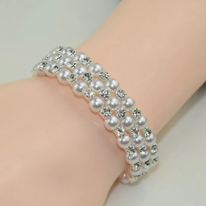 Macro shot of a triple-row pearl and rhinestone bracelet worn on a female wrist