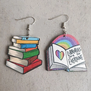 Detail of wooden earrings showing stacked books and rainbow library illustration