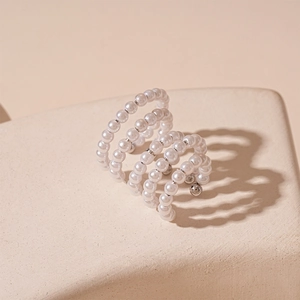 Macro detail of multi-layer faux pearl ear cuff with elegant vintage C-shape design