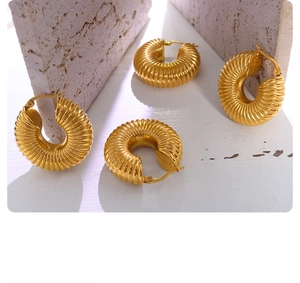 Detailed view of four chunky gold hoop earrings with spiral texture and snap-back closure