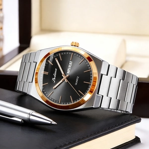 Detail view of a men's quartz watch with black dial and silver gold stainless steel strap