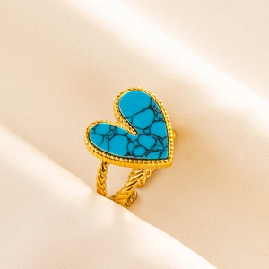 Close-up of gold stainless steel ring featuring a heart turquoise stone on silk background