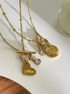 Macro shot of gold stainless steel OT buckle necklaces with Mom and Love My Kids pendants