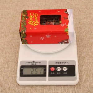 Close-up of a Merry Christmas gift box night light on a digital scale weighing 251g