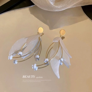 Elegante Maiglöckchen Ohrringe mit weißen Blütenblättern und goldenem Stiel auf Spiegel