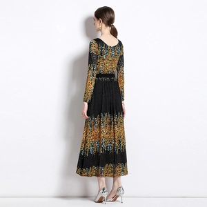 Elegante vestido largo de encaje con mangas largas y motivos florales en naranja y azul