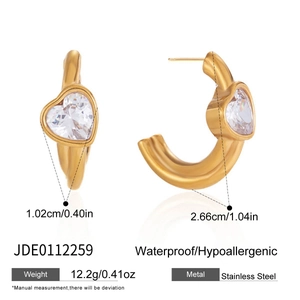 Detailed view of gold stainless steel C-shaped earrings with heart-cut zirconia accents