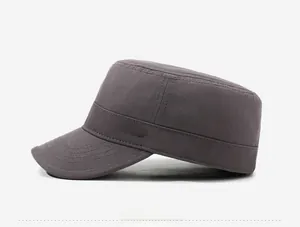 Detail of gray cotton flat top military cap featuring metal sports style emblem and stitching