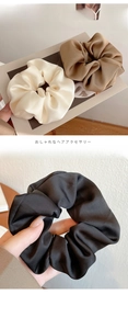 Detail of silk satin scrunchies in cream, brown, and black with a smooth lustrous finish