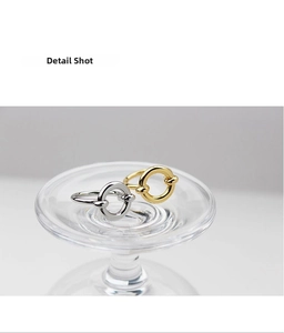 Detailed shot of interlocking gold and silver knot rings on a clear glass display