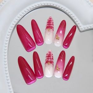 Press-on nails in rose red gradient featuring snake skin pattern and gold beads