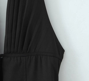 Detailansicht des schwarzen Plissee-Stoffes und der präzisen Nähte an diesem Kleid
