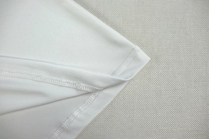 Detail of double-needle stitching and hemline on a white deep V-neck halter dress