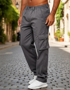 Close-up of men's dark grey multi-pocket cargo pants on a cobblestone street