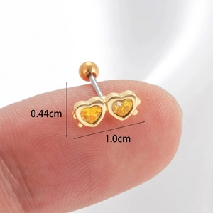 Macro shot of gold double heart cartilage stud on fingertip showing 1.0cm width scale