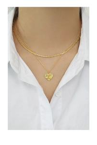Detail of layered gold heart necklace with embossed angel pendant on a female model