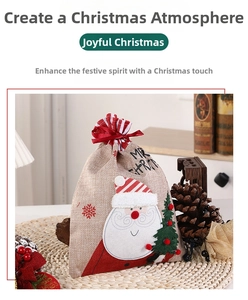 Detailed view of linen Christmas drawstring gift bag with Santa and tree embroidery