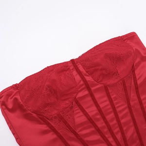 Detail of red lace corset dress featuring boning structure and satin fabric texture