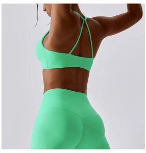 Detail view of mint green yoga set featuring a crisscross back bra and high-waist leggings