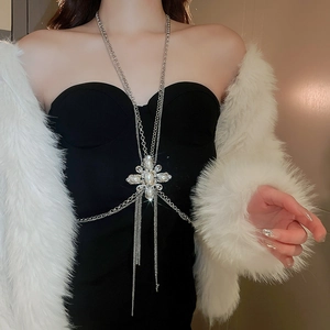 Detail of silver body chain with pearl flower pendant and rhinestone tassels on model